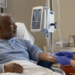 Nurse preparing IV treatment for a patient in a hospital room.